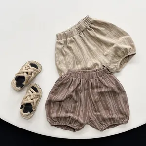 Close-up of children's tie-dye bloomers in khaki and cocoa with woven sandals
