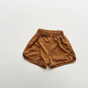 Detail view of caramel cotton shorts with elastic waistband and curved hem stitching