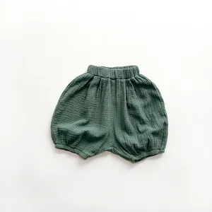 Detail of dark green muslin baby bloomer shorts with natural wrinkled texture