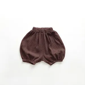 Close-up of deep brown baby bloomers featuring soft wrinkled cotton gauze fabric texture