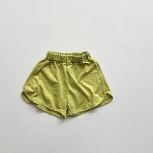 Detailed view of grass green cotton shorts featuring elastic waist and dolphin-cut hem