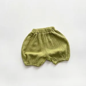 Detail of olive green cotton muslin baby bloomers with elastic waist and soft texture