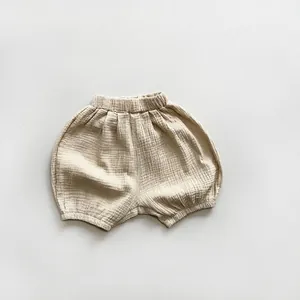 Detailed close-up of breathable cotton gauze fabric and elastic waistband on baby bloomers