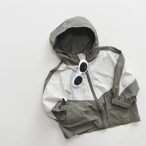 Detail of color-block kids windbreaker with hood and zipper in olive and cream