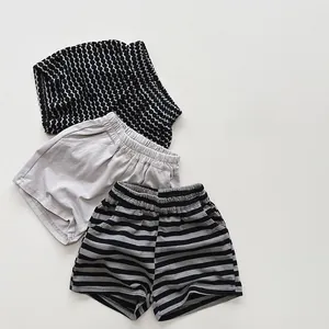 Detailed view of kids' summer shorts in polka dot, solid gray, and striped patterns