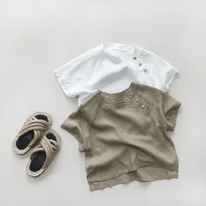 Flat lay of cotton linen children's shirts in white and khaki with wooden buttons