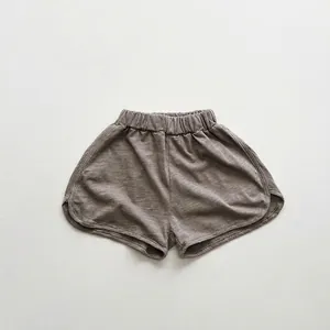 Detail of taupe bamboo cotton kids shorts featuring elastic high waist and side slits
