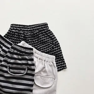 Three pairs of cotton summer shorts for kids in polka dot, striped and solid grey patterns