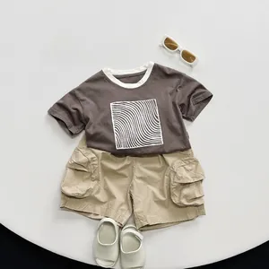 Flat lay of kids summer cotton set featuring brown tee with print and khaki cargo shorts