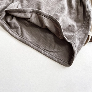 Close-up of slub cotton shorts hem showing double-needle stitching and fabric texture