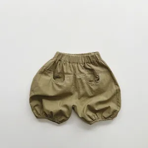 Detailed flat lay of olive green cotton linen kids bloomers with elastic waist and pockets
