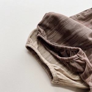 Detail of ribbed cotton kids shorts in dark brown and khaki with elastic waist texture