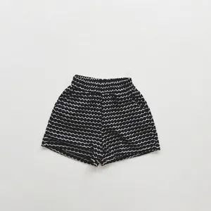 Flat lay detail of kids summer shorts with black and white texture and elastic waistband