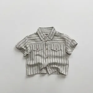 Détail de la chemise rayée en coton montrant la texture vintage et les poches