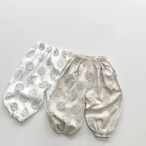 Detailed macro view of the printed cotton fabric and elastic waistband on baby pants