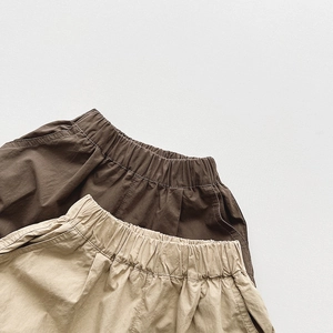 Detail view of cotton cargo shorts for kids in dark brown and light khaki colors