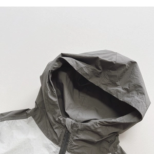 Close-up of lightweight color-block hooded windbreaker with zip closure and clean stitching