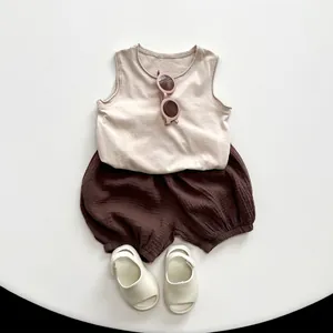 Summer kids outfit with beige tank top, brown lantern shorts, sandals and pink sunglasses
