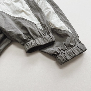 Detail of color-block hooded sunscreen jacket featuring elastic cuffs and windproof fabric