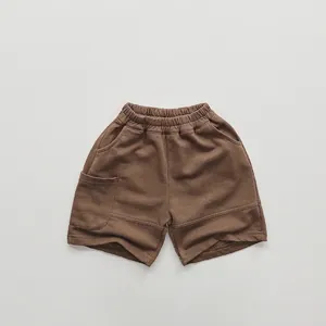 Detail of children's brown cotton knit shorts featuring elastic waist and side pocket