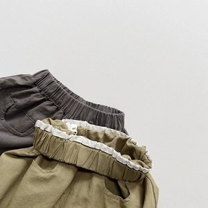 Detail of elastic waistbands and premium cotton fabric on grey and olive kids shorts