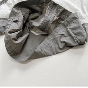 Detailed interior of color-block sun protection jacket showing zipper and stitching