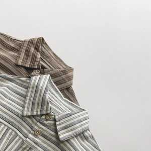 Détail de chemises rayées en coton montrant la texture du col et la finition des boutons