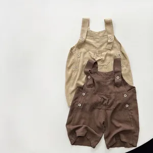 Détail de la salopette enfant en coton lin montrant la texture et les boutons