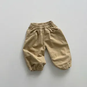 Detail of khaki kids cargo pants with elastic waist and reinforced knee stitching