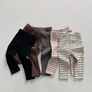 Detail of ribbed cotton leggings for kids showing black, brown, and striped texture