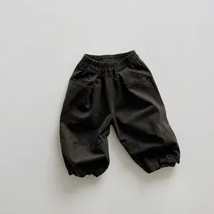 Detail view of elastic waistband and gathered hem on kids loose cargo lantern pants