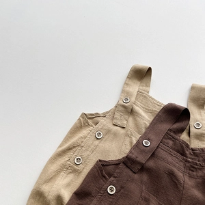 Détails de salopette enfant en lin et coton montrant les boutons et la texture du tissu