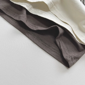 Nahaufnahme des Baumwoll-T-Shirt-Saums mit sauberer Doppelnaht-Verarbeitung im Detail