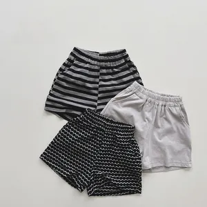 Detailed flat lay of three pairs of cotton shorts for toddlers in stripes, solid and polka dots