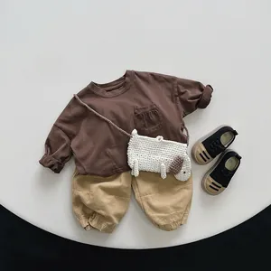 Mise à plat de t-shirt marron, pantalon kaki et sac chien au crochet pour enfants