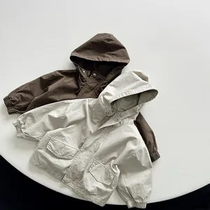 Detail of high-density cotton kids' hooded jackets in brown and beige with large pockets