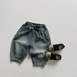 Détail d'un jean vintage pour enfant avec taille élastique et texture bleu délavé