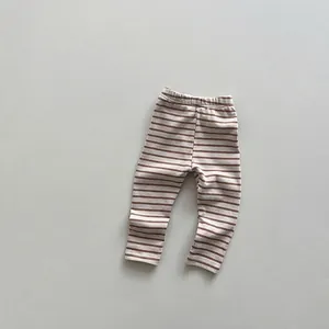 Detail view of neutral striped cotton knit leggings with an elastic waistband for toddlers