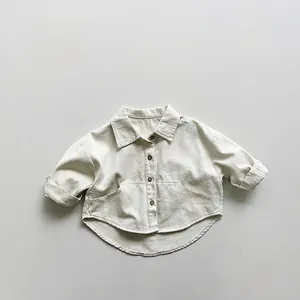 Détail d'une chemise beige en coton pour enfant avec grandes poches et texture canevas