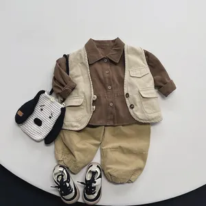 Flat lay of brown shirt, beige vest, and khaki pants with a small dog-shaped knit bag