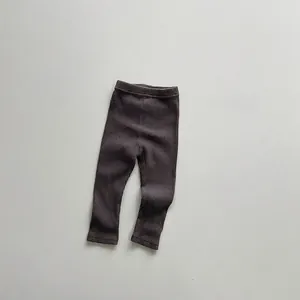 Close-up of dark brown ribbed knit baby leggings with elastic waistband and soft texture