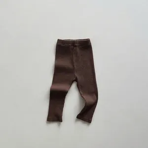 Detailed macro shot of dark brown ribbed knit cotton fabric for kids leggings