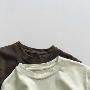 Detail der Rippbündchen und Baumwollstoffe bei braunen und beigen Kinder-T-Shirts