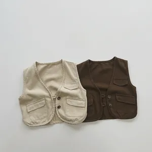 Dettaglio di gilet utility in cotone per bambini beige e marroni con tasche cargo