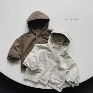 Detail of brown and off-white hooded jackets with large pockets and elastic cuffs