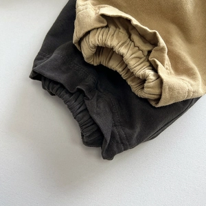 Detail of elastic waistbands and ribbed cuffs on charcoal and khaki cotton kids pants
