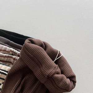 Close-up of assorted ribbed knit leggings for children in solid colors and striped patterns