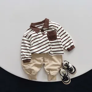 Flat lay of brown striped polo shirt and khaki jogger pants with sneakers set