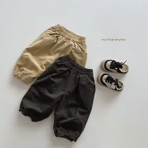 Detailed close-up of kids' elastic waist joggers in khaki and brown cotton twill fabric