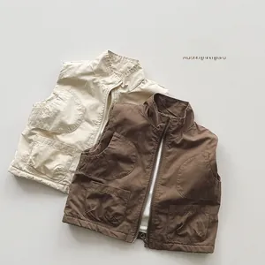 Close-up of beige and brown kids cargo vests showing durable cotton fabric and large pockets